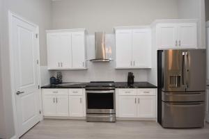 a kitchen with white cabinets and a stainless steel refrigerator at Modern 3BR Retreat Heated Pool & Large Game Room in Bunnell