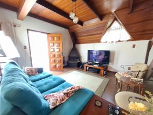 a living room with a blue couch and a tv at Linda Cabana 3 Quartos a 50m da Praia in São Lourenço do Sul