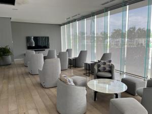 a waiting room with chairs and tables and a tv at Marítima Playa Flamingos Renting 5i Richards in Bucerías