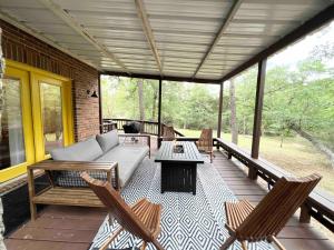 a screened in porch with a couch and chairs at Swim Spa Billiards in Pineforest Spacious Home in Bastrop