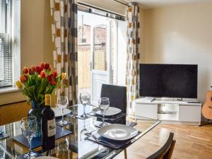 a dining room with a table and a television at 1 Kirkby Cottages in Sheriff Hutton