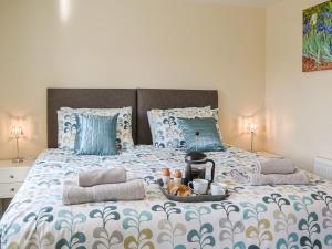 a large bed with a tray of food on it at 1 Kirkby Cottages in Sheriff Hutton +11 photos