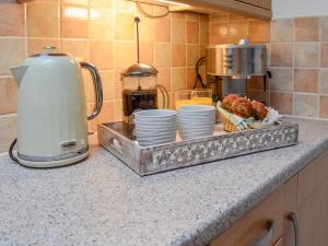 encimera de cocina con bandeja de platos y cafetera en Seahaven Cottage, en Portknockie