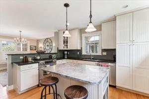 une cuisine avec des armoires blanches et un comptoir en marbre dans l'établissement Landmark Meadows, à Stowe Fork