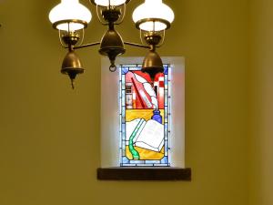 a stained glass window hanging on a wall at The Old School Penallt in Mitchel Troy +8 photos