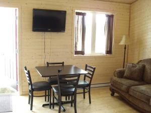 salon ze stołem, krzesłami i kanapą w obiekcie The Country Inn Cottage w mieście Gander