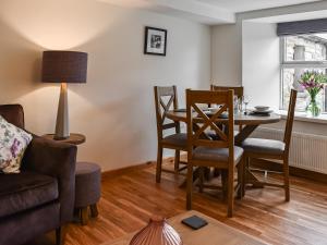 ein Wohnzimmer mit Esstisch und Stühlen in der Unterkunft Ivy Cottage in Dent