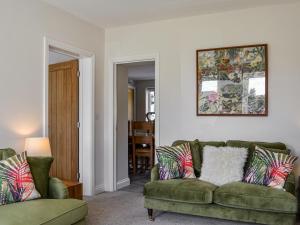 a living room with a couch and two chairs at Southways Cottage in Cumwhinton
