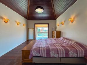 Casa Paraíso في بوزيوس: غرفة نوم بسرير وسقف مع انارة