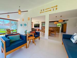 Casa Paraíso في بوزيوس: غرفة معيشة مع أرائك زرقاء وغرفة طعام