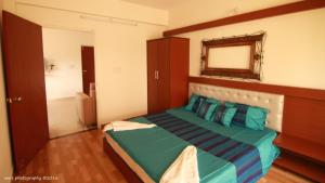 a bedroom with a bed with a mirror and a bathroom at Goa Fiesta in Arpora