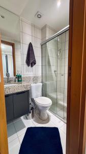 a bathroom with a toilet and a glass shower at Apartamento moderno com uma ótima área de lazer in Brasilia +4 photos