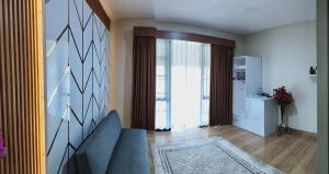 a living room with a blue couch and a large window at Pondok Indah Teluk Asmara in Roworante