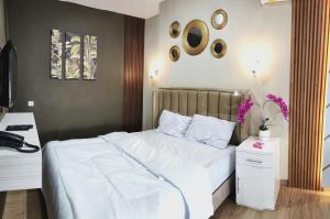 a bedroom with a white bed and a desk at Pondok Indah Teluk Asmara in Roworante +10 photos