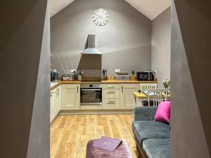 a kitchen with a couch and a clock on the wall at Ling At Holly House - Uk44468 in Newton