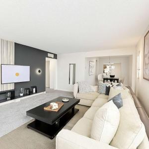 a living room with a white couch and a table at Saltwater Pool 2BR Near Galleria Walkable, Stylish & Central Marquee Uptown in Houston