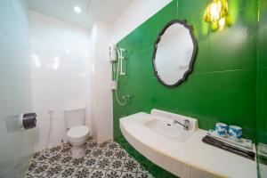 a green bathroom with a sink and a toilet at Nyonya Maison Boutique Hotel Phuket Old Town in Phuket Town +206 photos