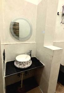 Un baño con un lavabo y un espejo sobre un mostrador. en Haveli near the lake, en Udaipur 42 fotos más