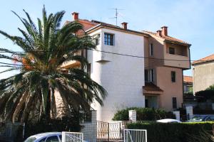 een gebouw met een palmboom ervoor bij Apartments Žuvela in Split