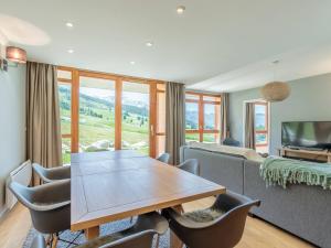a living room with a table and chairs and a couch at Superbe 4 pièces moyen pour 6 pers. avec piscine, spa, fitness, parking couvert, ski aux pieds - FR-1-352-68 in Arc 1800