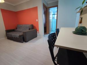 een woonkamer met een bank en een tafel bij Apartamento aconchegante e tranquilo Suzano in Suzano
