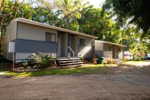 una casa con porche y escaleras a ella en Tropical Hibiscus Caravan Park, en Mission Beach