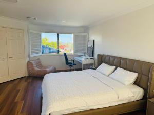 a bedroom with a bed and a desk with a computer at Spacious Family Retreat with Pool in Carindale in Brisbane +19 photos