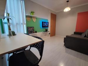 een woonkamer met een tafel en een bank bij Apartamento aconchegante e tranquilo Suzano in Suzano