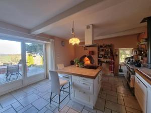 a kitchen with a counter and a table with chairs at Gîte charmant avec sauna privatif et cheminée - FR-1-496-372 in La Côte-en-Couzan