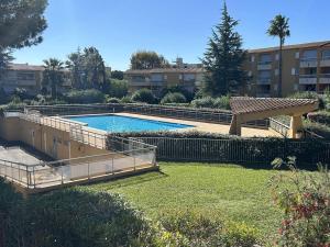 ein Pool in einem Hof neben einem Gebäude in der Unterkunft Studio rénové pour 2 personnes au Lavandou avec parking - FR-1-251-871 in Le Lavandou