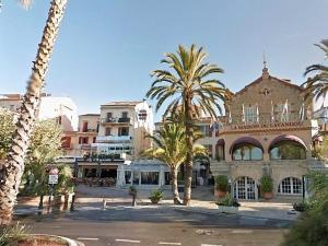 ein Gebäude mit Palmen vor einer Straße in der Unterkunft Studio rénové pour 2 personnes au Lavandou avec parking - FR-1-251-871 in Le Lavandou + 6 Fotos