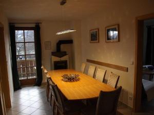 una sala da pranzo con tavolo in legno e camino di Holiday apartment with 4 bedrooms a Garmisch Altre 11 foto