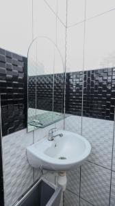 a bathroom with a sink and a mirror at NiHOTEL Cibaduyut Bandung in Bandung