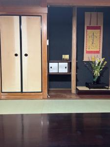 a room with two glass doors and a vase of flowers at 宿坊宝塔寺蓮Ren一棟貸 in Yoshino
