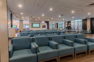 a waiting room with blue chairs and tables at Holiday Inn Resort South Padre Island-Beach Front by IHG in South Padre Island
