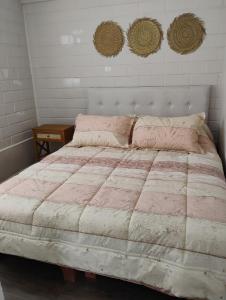 a bedroom with a large bed with a pink comforter at Descanso y Confort en La Serena in La Serena