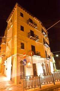 a tall yellow building at night with at Beatus Suites And Rooms B&B in Canicattì