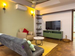 a living room with a couch and a flat screen tv at Gracious Green Gurney in George Town