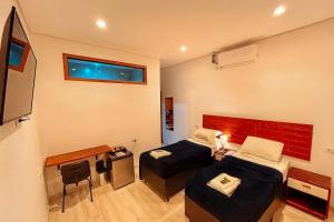 a room with two beds and a desk and a television at Bistu Hotel - Vila Nova Conceição in São Paulo