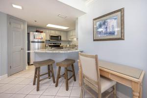 a kitchen with a table and stools in a room at Phoenix VI 61004 in Orange Beach