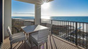 a balcony with a table and chairs and the ocean at Phoenix VI 61004 in Orange Beach
