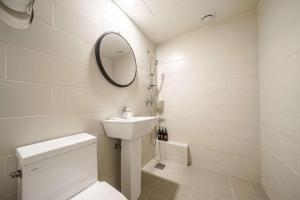 a bathroom with a toilet and a sink and a mirror at Hotel Yam - Paju Geumchon in Paju +30 photos