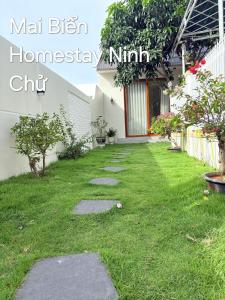 a garden of a house with a green lawn at Homestay Mai Biển Ninh Chử in Thôn Mỹ Nghĩa