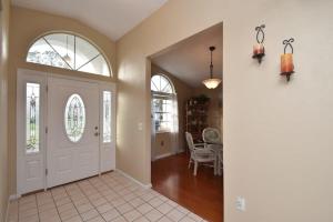a hallway with a white door and a dining room at Cozy Family Pool Home in Palm Coast in Palm Coast