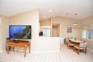 a living room with a table and a tv on a wall at Cozy Family Pool Home in Palm Coast in Palm Coast +69 photos