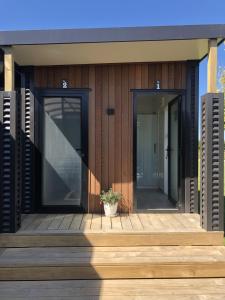 ヘイスティングズにあるA Rural Retreat, Cabin with Private Bathroom No 2の木製デッキ上のガラス戸2枚付きの家