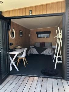 ヘイスティングズにあるA Rural Retreat, Cabin with Private Bathroom No 2のベッドとテーブルと机のある寝室