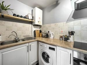 a kitchen with a washing machine and a sink at The Rise in Scarborough