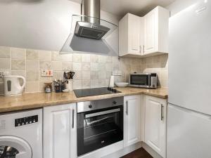 a kitchen with white cabinets and a sink and a microwave at The Rise in Scarborough