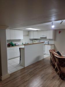 a kitchen with white cabinets and a table and a couch at A Place to Call Home in Edmonton